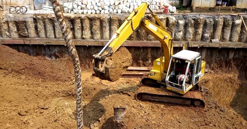 Deep excavation site in Dubai showing sheet pile shoring and excavator